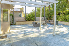 Panorama Frame Patio With A White Wooden Pergola Attached To The Wall Of The Home