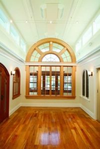 Large half-circle topped window with wood-stained frame inside home