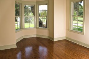 four windows in a room with hardwood flooring
